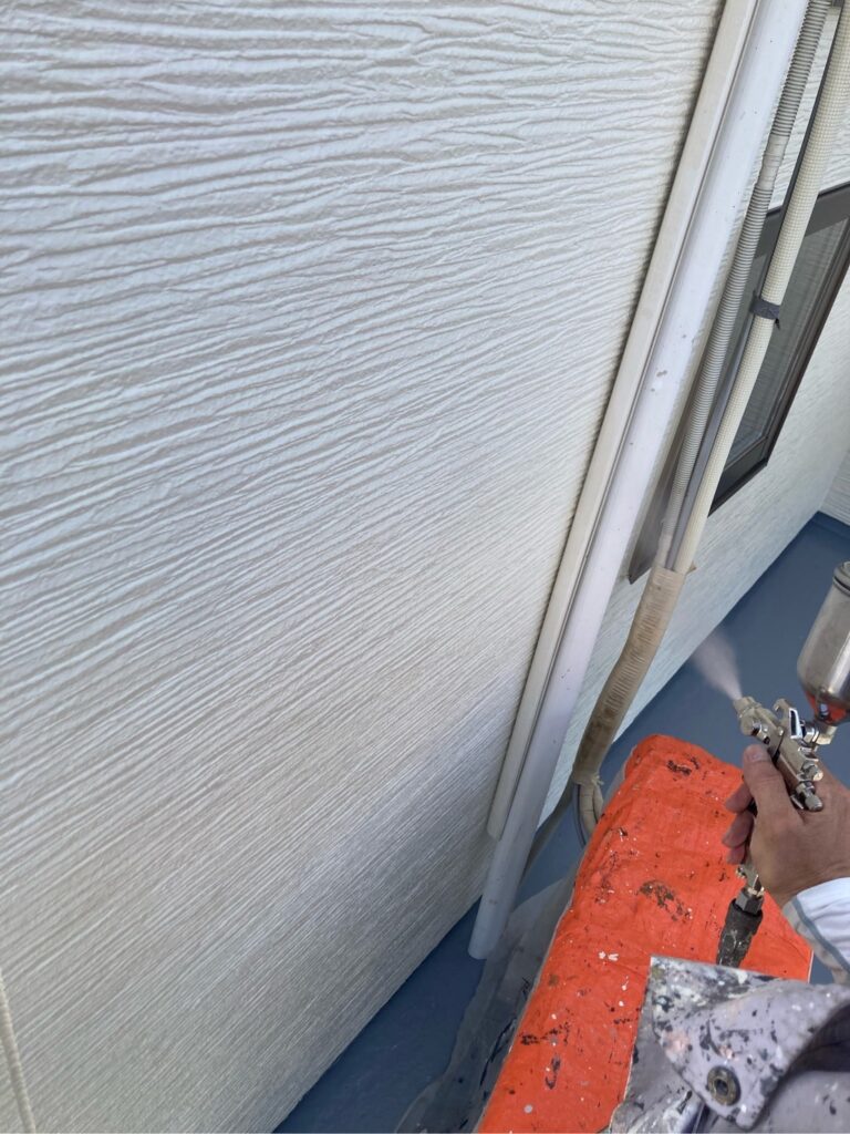 壁に仕上げ材の光触媒プロテクトコーティング（クリスタルシーズンtg）を塗布します。