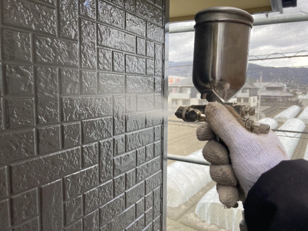 壁に仕上げ材の光触媒プロテクトコーティング（クリスタルシーズンtg）を塗布します。